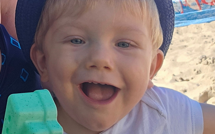 Uśmiechnięty chłopiec bawiący się na plaży.