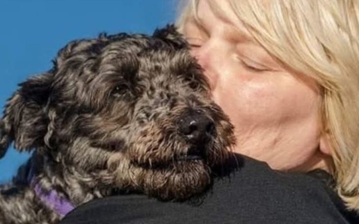 Kobieta przytulająca psa, pełna miłości i radości.