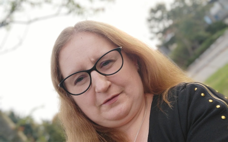 Kobieta w okularach, z poważnym wyrazem twarzy.