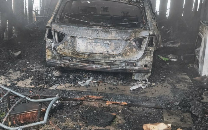 Spalony samochód w zniszczonym pomieszczeniu.