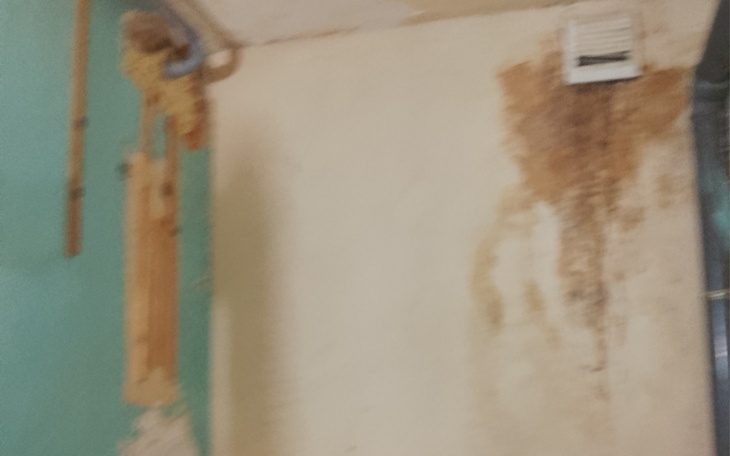 Zniszczona ściana z pleśnią i odbarwieniami, wymagająca remontu.