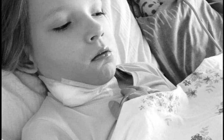 Dziecko w szpitalu, z wyraźnym zmęczeniem i niepokojem.