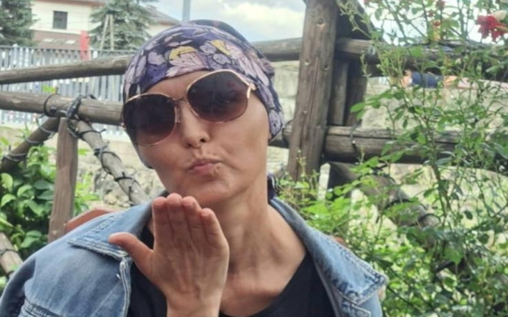 Kobieta w okularach przeciwsłonecznych, całująca w powietrze.