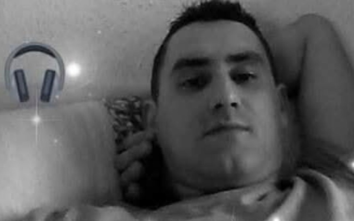 Mężczyzna leżący na łóżku, pozujący do zdjęcia.