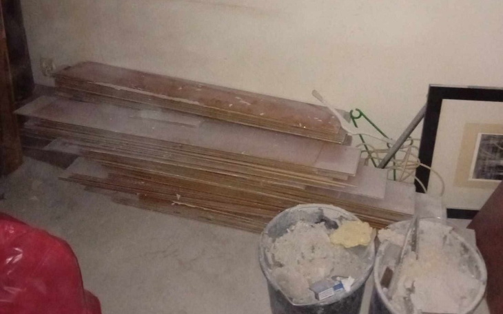 Stos płyt w pomieszczeniu, z kurzem i bałaganem.