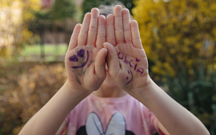 Dziecięce dłonie z rysunkami i imieniem Olcia.