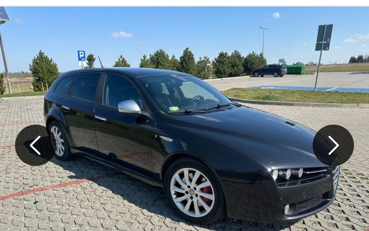 Czarny samochód osobowy zaparkowany na parkingu.