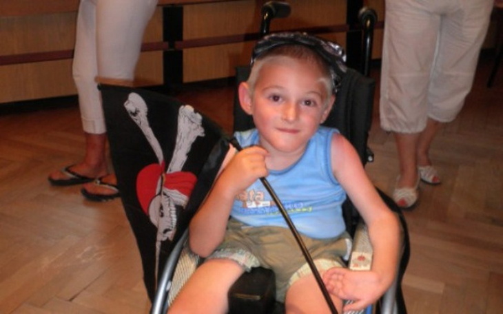 Chłopiec w wózku z flagą piracką.