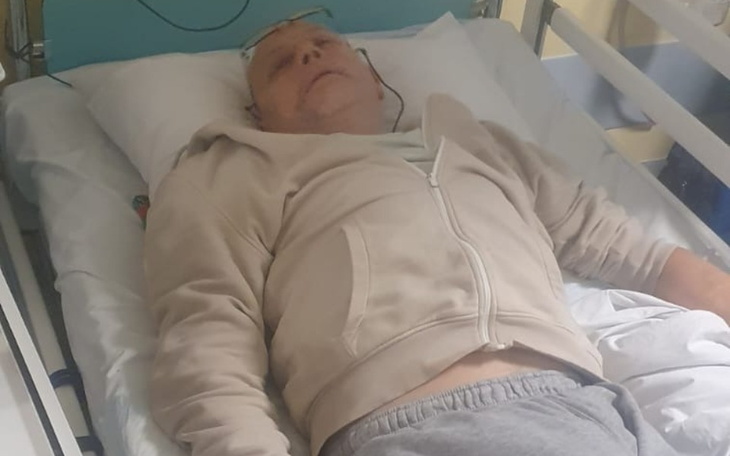 Mężczyzna leżący w szpitalnym łóżku.