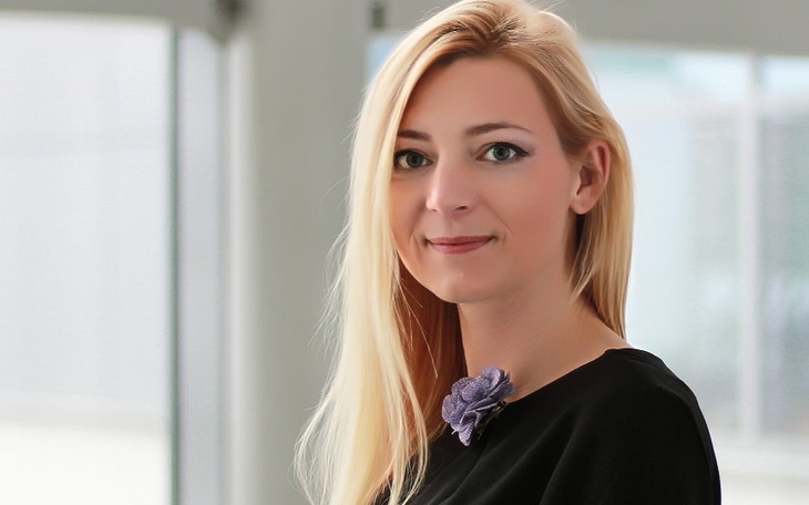 Uśmiechnięta kobieta w eleganckim stroju.