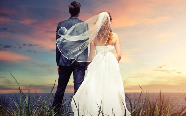 Para młoda stojąca na tle zachodzącego słońca.