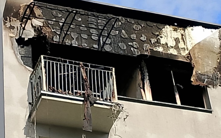 Zniszczony balkon po pożarze, z widocznymi śladami spalenizny.