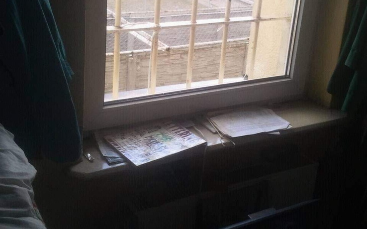 Okno z widokiem na zewnętrzny świat, z dokumentami na parapecie.