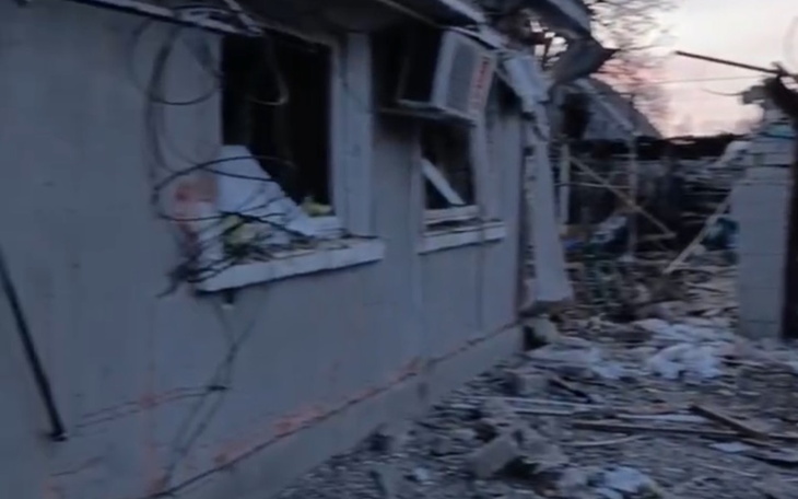 Zniszczony budynek z oknami i gruzem wokół.