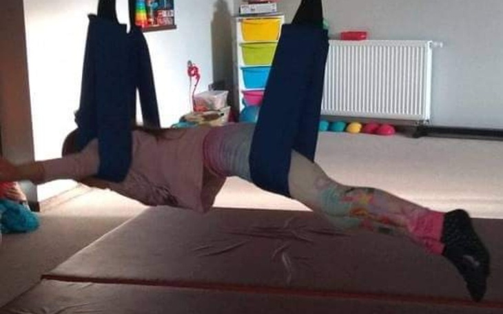 Dziecko w specjalnym sprzęcie do rehabilitacji, w ruchu.