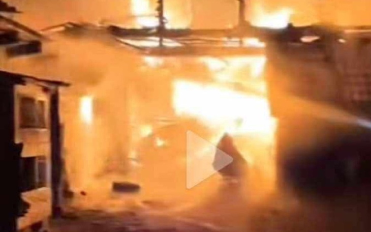 Pożar w budynku, dym i ogień widoczne w tle.