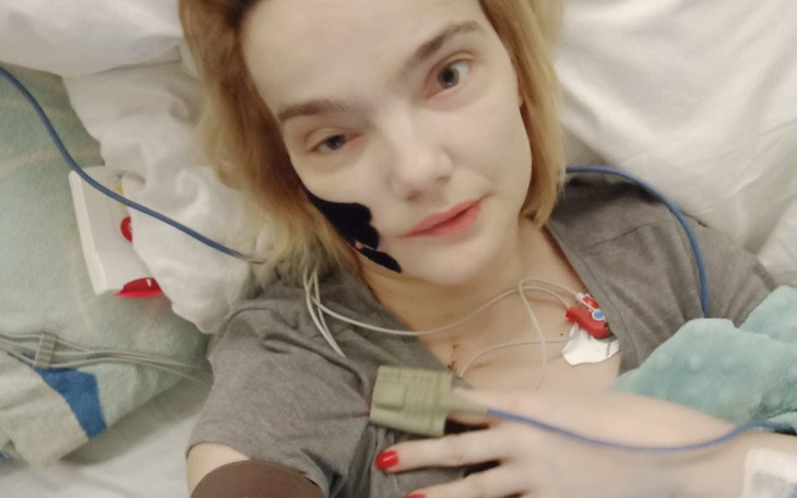 Kobieta w szpitalu, z monitorami i kroplówką.