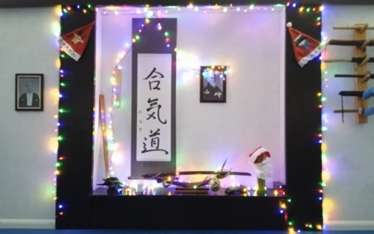 Ozdobiona przestrzeń z napisem w języku japońskim i świątecznymi dekoracjami.