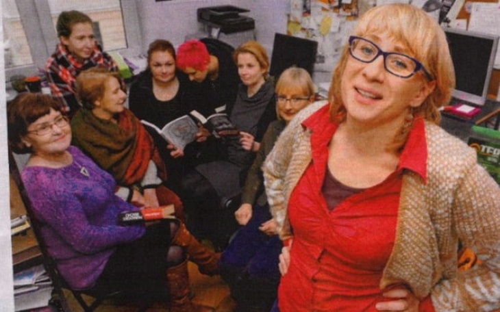 Grupa kobiet w biurze, jedna z nich uśmiechnięta.