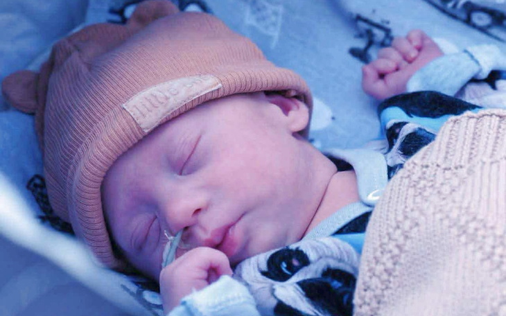 Śpiące niemowlę w czapce z uszami.