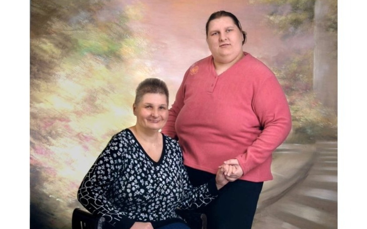 Dwie kobiety pozują razem na tle malowniczego tła.