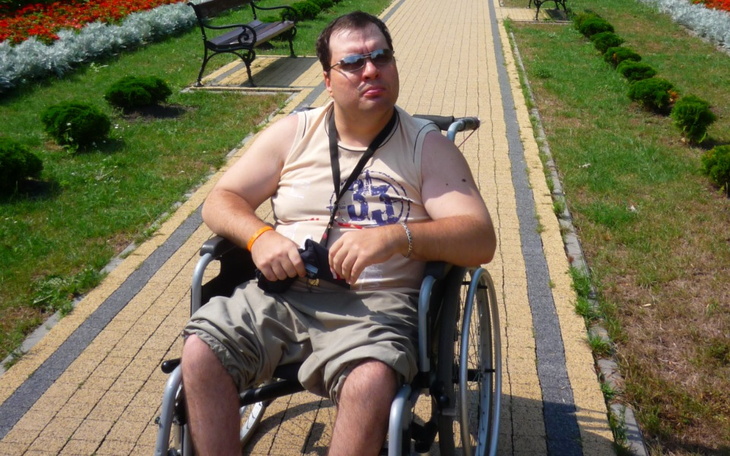 Mężczyzna na wózku inwalidzkim w parku.