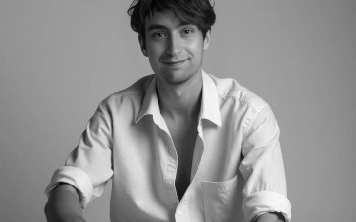 Młody mężczyzna uśmiechający się do kamery.