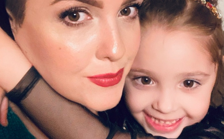 Kobieta z dzieckiem, obie uśmiechnięte.