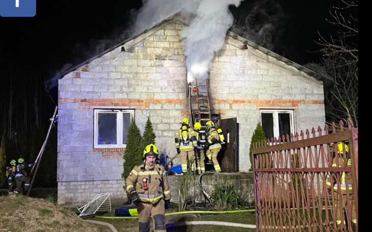 Strażacy gaszący pożar w budynku mieszkalnym.