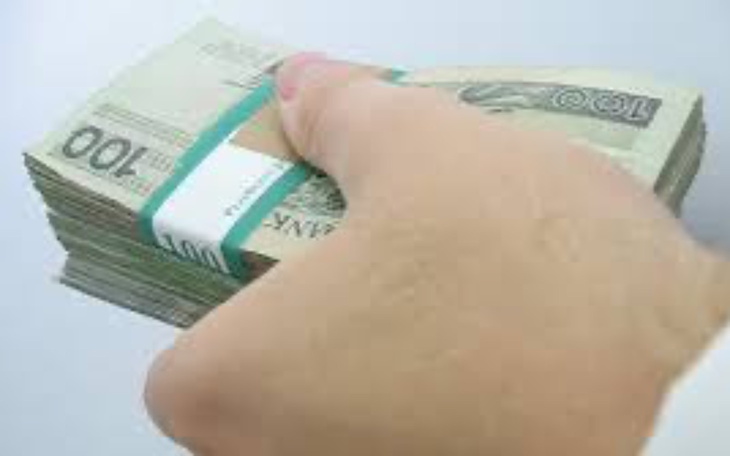 Ręka trzymająca stos banknotów, gotówka w dłoni.