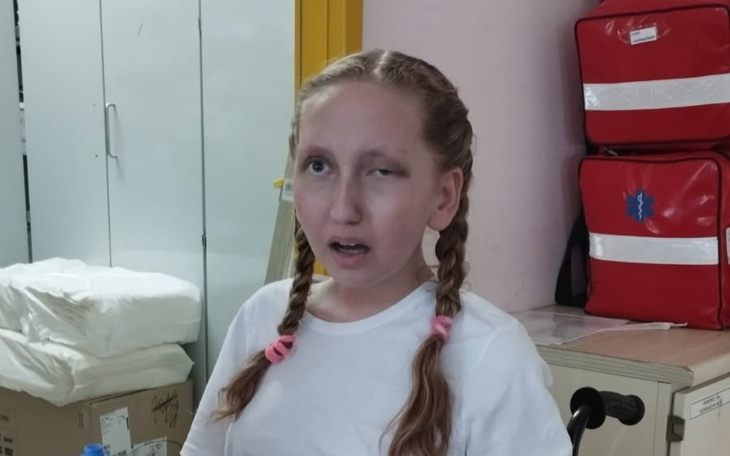 Dziewczynka z warkoczami w szpitalu, z wyrazem twarzy pełnym emocji.