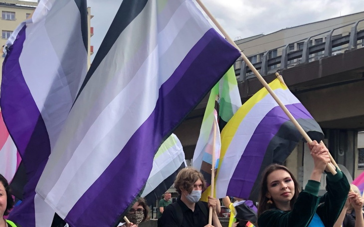 Osoby z flagami na paradzie równości.