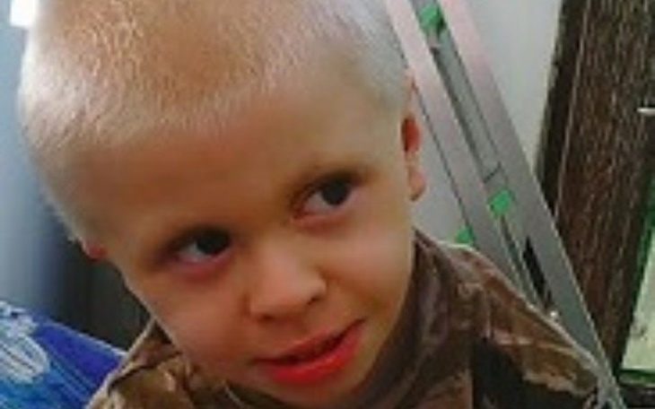 Chłopiec z krótkimi włosami, uśmiechający się do kamery.