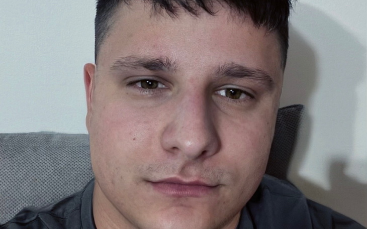 Mężczyzna robiący selfie, siedząc na kanapie.