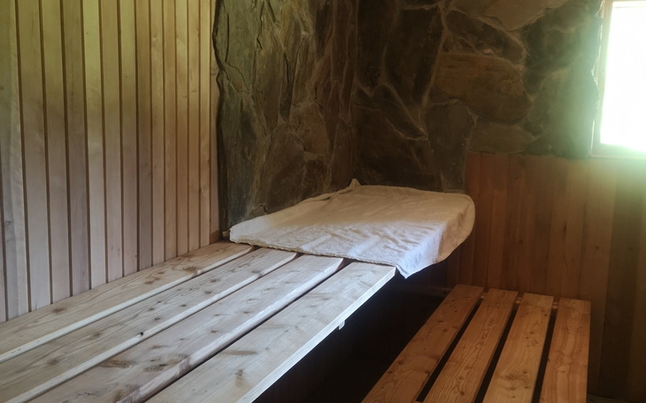 Sauna z drewnianymi ławami i kamieniami.