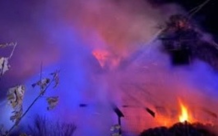 Pożar budynku, dym i płomienie w nocy.