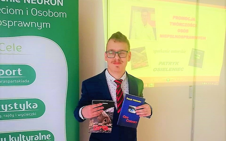 Patryk Osieleniec prezentuje swoje książki podczas wydarzenia promocyjnego.