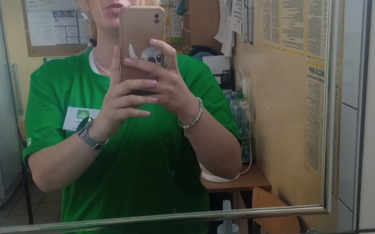 Osoba w zielonej koszulce, selfie w lustrze.