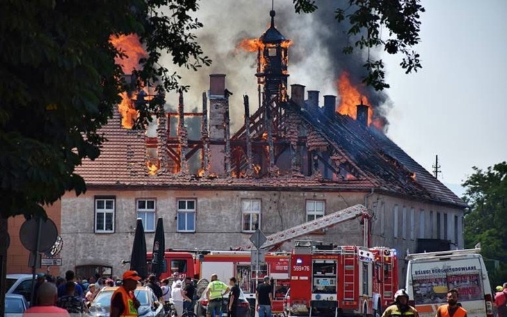Zza okna widoczny ruch uliczny i gaśnica na miejscu zdarzenia.