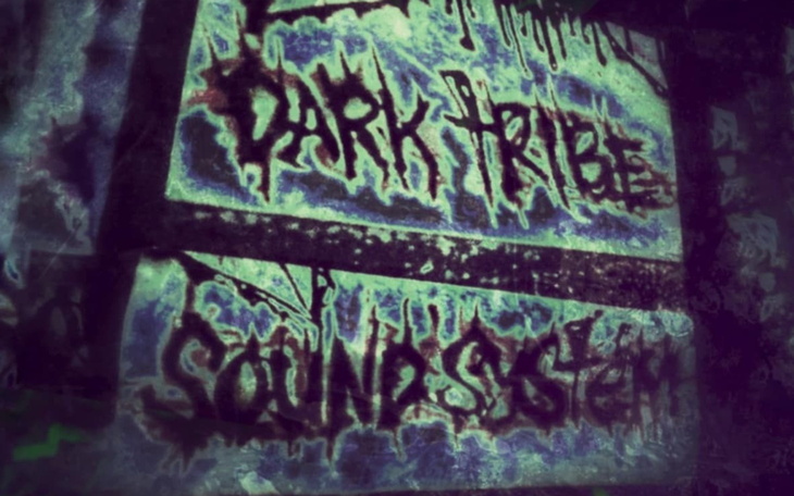 Graffiti na ścianie z napisem 'Dark Tribe Sound System'.