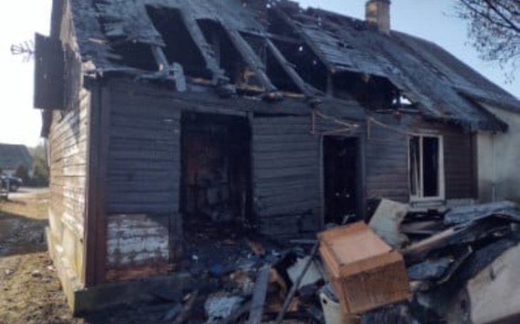 Zniszczony dom po pożarze, z widocznymi uszkodzeniami.