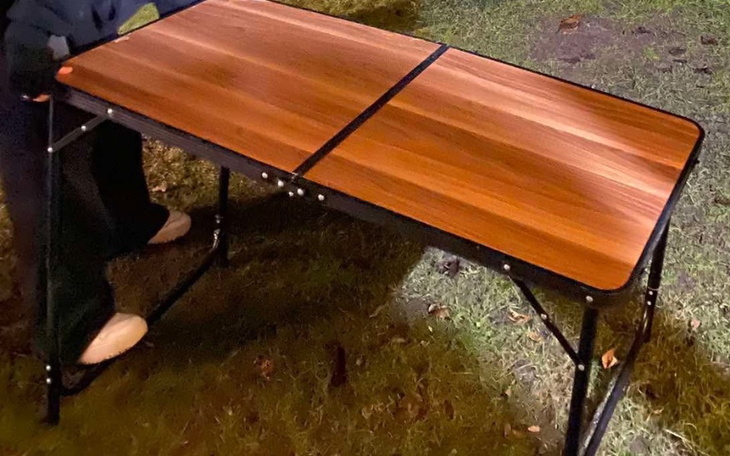 Składany stół na trawie, przygotowany do użytku.