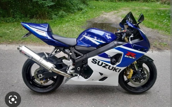 Motocykl Suzuki GSX-R w niebiesko-białym kolorze, stojący na drodze.