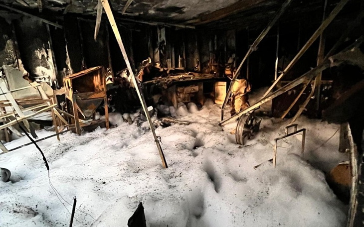 Zniszczone wnętrze po pożarze, z pozostałościami mebli.