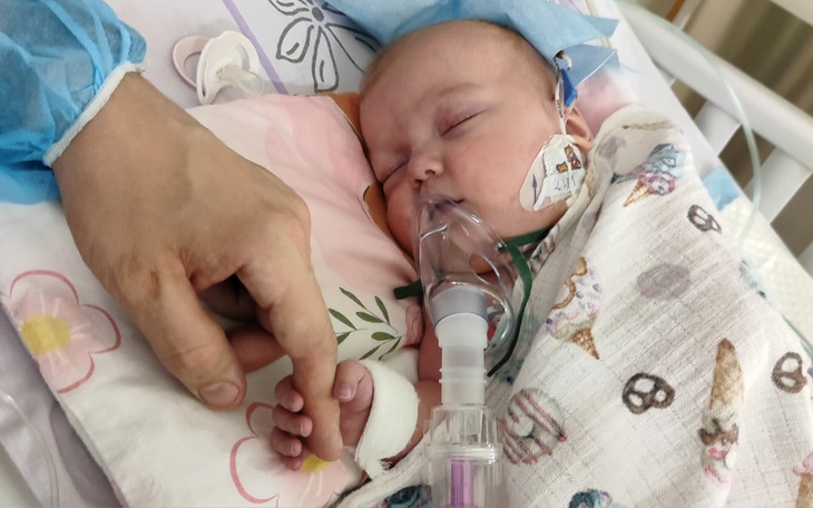 Noworodek w szpitalu, trzymający dłoń rodzica.