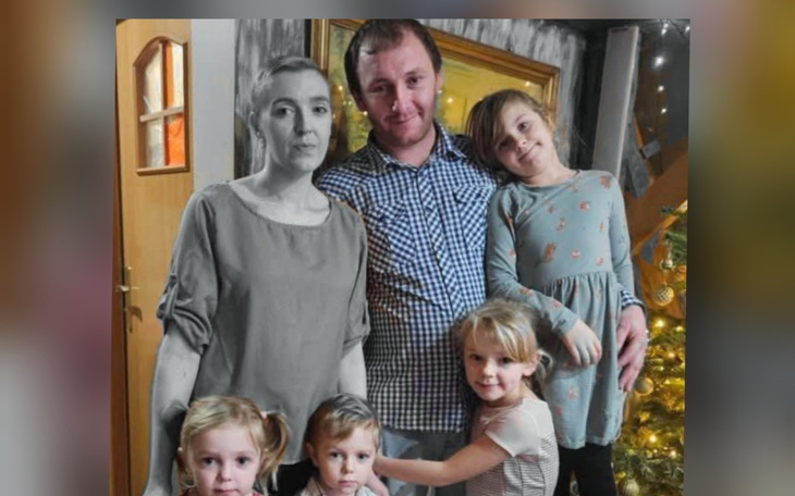 Rodzina z dziećmi, pozująca do zdjęcia w domowym otoczeniu.