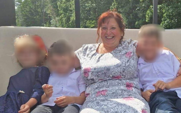 Uśmiechnięta kobieta z dziećmi, chwile radości na świeżym powietrzu.