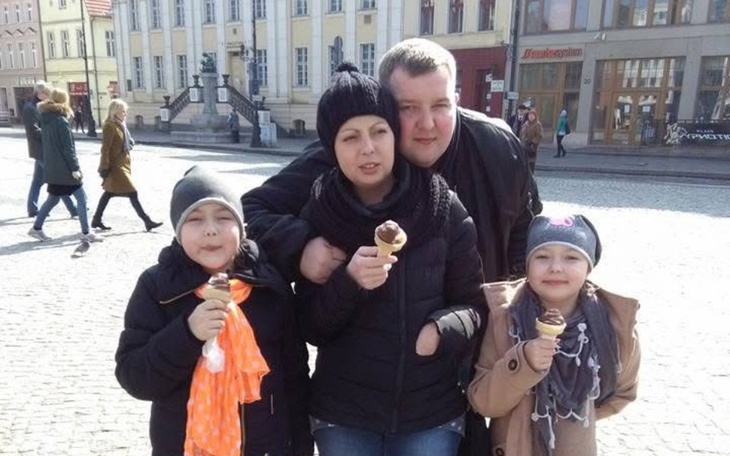 Rodzina z dwójką dzieci trzymających lody na ulicy.