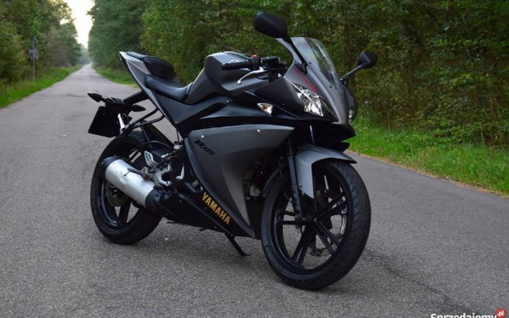 Motocykl na leśnej drodze, gotowy do jazdy.