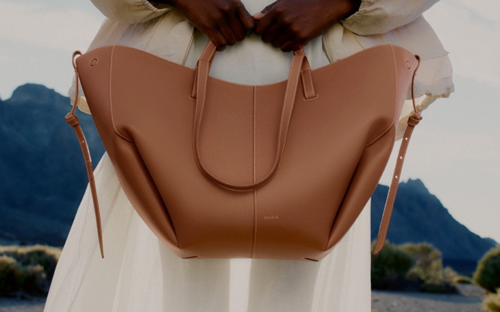Stylowa torba w rękach modelki na tle gór.